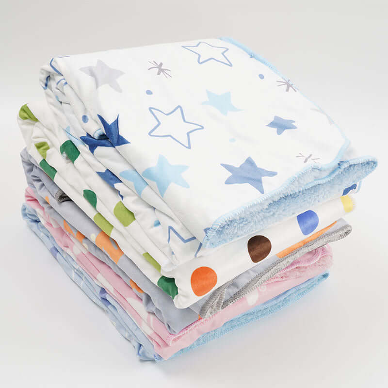 stack of Ultra- soft plush baby blankets in different designs